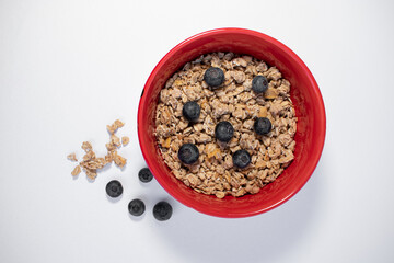 red bowl with cereals and blueberries