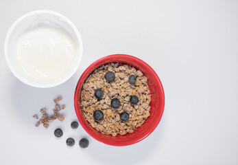 red bowl with cereals, blueberries and yogurt