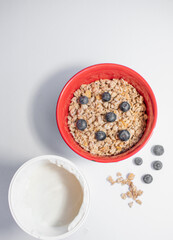red bowl with cereals, blueberries and yogurt