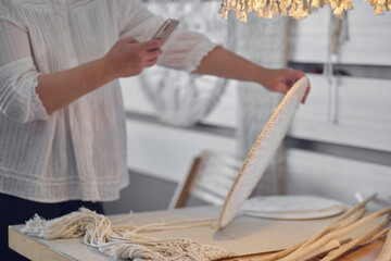 craftswoman photographs her product for sale on the Internet. hobby as a source of income. elderly lady takes off her embroidery on the phone to post it on social networks