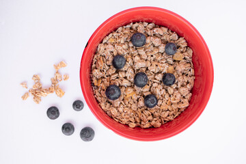 red bowl with cereals and blueberries