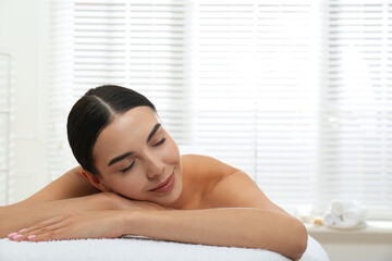 Beautiful young woman relaxing in spa salon