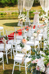 Chairs for a wedding ceremony decorated with pink flowers