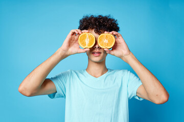 Cheerful curly guy with oranges in his hands fruits lifestyle