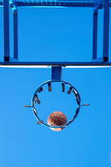 Street basketball ball falling into the hoop.