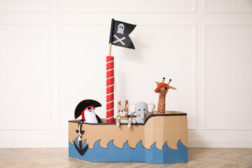 Pirate cardboard ship and toys near white wall indoors
