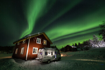 aurora boreal de noche estrellada con casa furgoneta y nieve de fondo