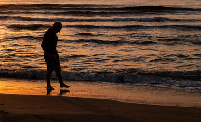 Fototapeta na wymiar Portrait of adult man on beach during sunrise