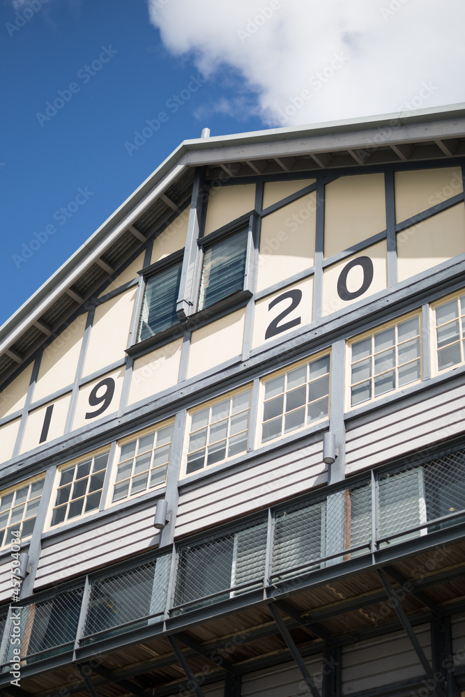 Wall mural historic facade finger wharf building timber 1920 windows blue sky looking up old