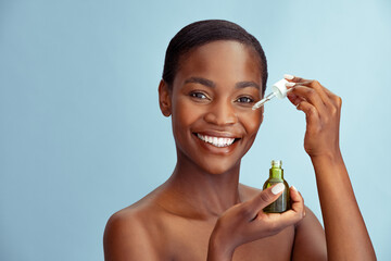 Beauty african woman showing pipette with hydrating facial serum