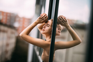 young smiling beautiful woman enjoying her morning near big window