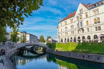 Fototapeta na wymiar Tromostovje bridge on Ljubljanica river with river bank