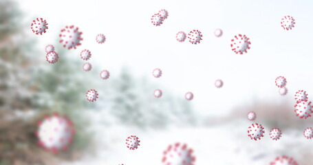 Image of covid 19 cells moving over winter scenery with fir trees in the background