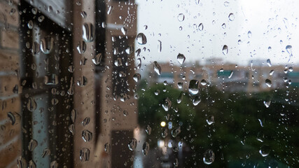 Naklejka na ściany i meble raindrops on the window looking at the city