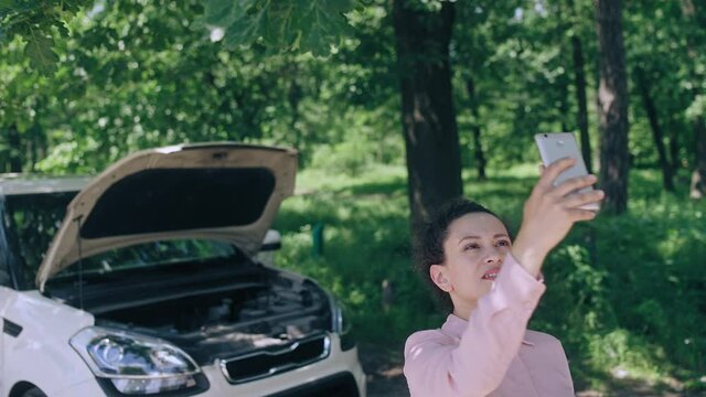 Stressed female driver trying to contact car repair service on the roadside