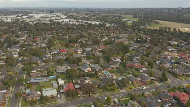 Aerial perspective tracking utility van in the foreground beside a major arterial.