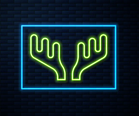 Glowing neon line Deer antlers icon isolated on brick wall background. Hunting trophy on wall. Vector