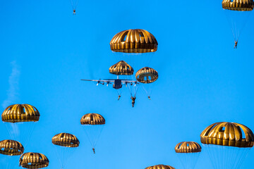 paratroopers jumping from a military plane