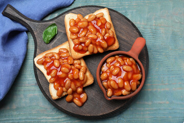 Toasts with delicious canned beans on light blue wooden table, top view