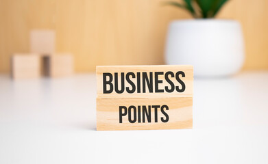 On a light background, wooden cubes and a wooden block with the text business points. View from above