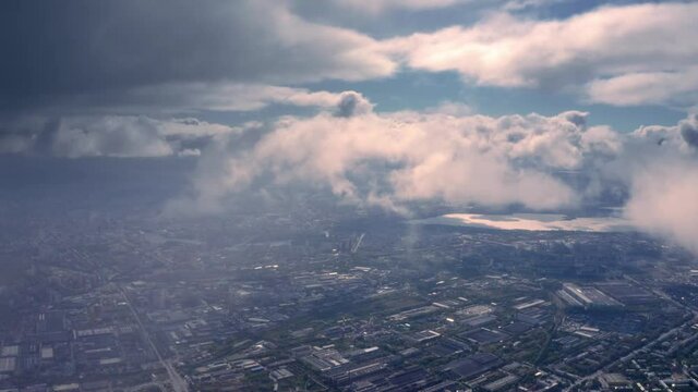 Aerial view of large city seen through moving clouds.
