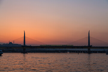 トルコ　イスタンブールの金角湾にかかる新市街と旧市街をつなぐ橋と夕焼けでオレンジに染まった空