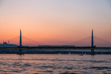 トルコ　イスタンブールの金角湾にかかる新市街と旧市街をつなぐ橋と夕焼けでオレンジに染まった空