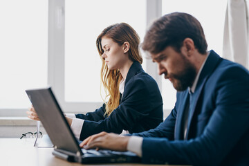 business man and woman sitting in front of a laptop teamwork internet officials