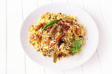 Halal Indian chicken Biryani with chili on plate. White wooden background. Selective focus. Top...