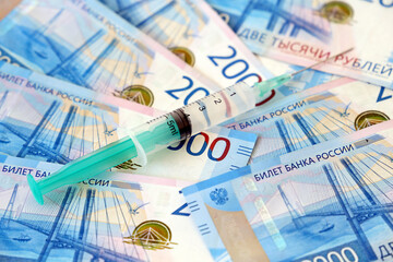 Syringe on russian rubles background, vaccination in Russia. Concept of health care and economy during covid-19 pandemic