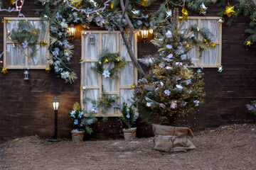 Christmas facade of a wooden house with Christmas trees, wreath, garlands.