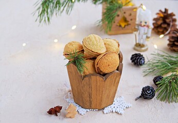 Shortbread cookies Nuts stuffed with chocolate paste or condensed milk in a wooden jar in a Christmas and New Year style on a light concrete background. Cookie recipes.