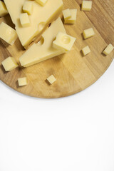 Sliced emmental cheese on a cutting board. Vertically, from above on a white background