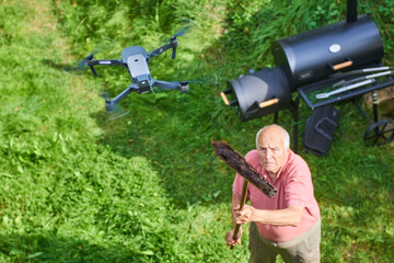Old senior man upset by a flying drone over his garden. The concept of spying on neighbors and...