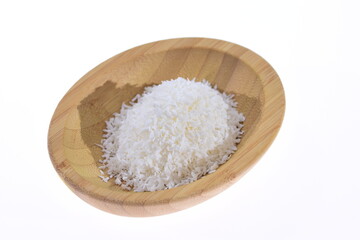 Fototapeta na wymiar Coconut shavings in a wooden bowl against a white background. Food.