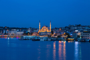 Fototapeta na wymiar トルコ　イスタンブールの金角湾の夜景と旧市街にあるライトアップされたニューモスク