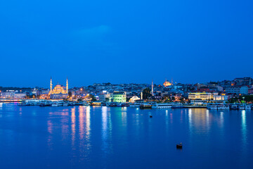 Fototapeta na wymiar トルコ　イスタンブールの金角湾の夜景と旧市街にあるライトアップされたニューモスク