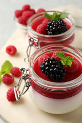 Delicious panna cotta with fruit coulis and fresh berries on table, closeup