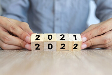 hand turning wooden cube from 2021 letters to 2022 letters