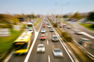 Vehicles on the urban road. Radial zoom blur filter effect applied.
