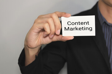 man hand holding business card with content marketing letters