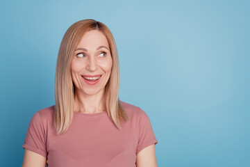 Obraz premium Photo of young excited woman happy positive smile dream curious look empty space isolated over blue color background