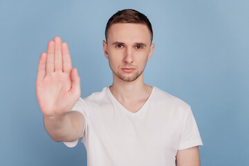 Photo of young handsome man unhappy sad show no stop sign decline refuse isolated over blue color background