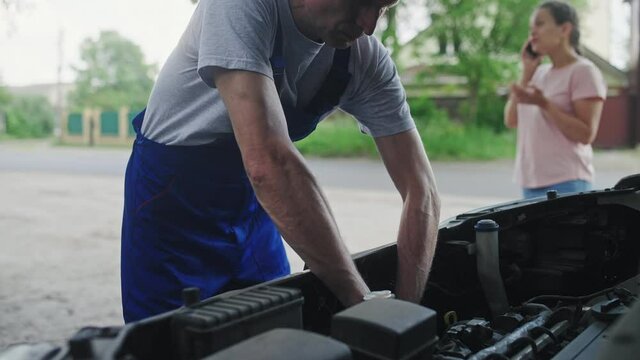 Professional technician fixing auto problem on roadside, car service, trouble