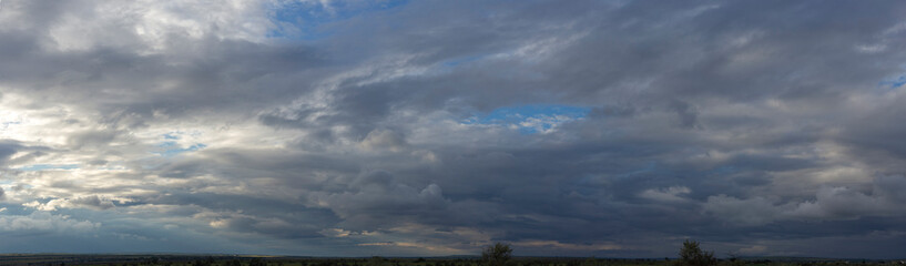 Storm clouds cover the landscape. Tragic gloomy sky. Panorama. Fantastic sky.