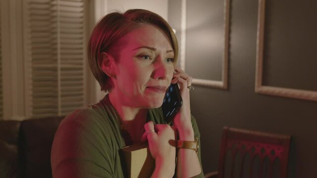 A woman is shaking and calling a number to help get rid of ghosts.