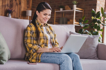 Photo of charming cheerful people sitting on couch beaming smile write typing social network user...