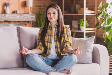 Photo of peaceful sporty lady practice yoga training barefoot sit cozy couch wear plaid shirt home indoors