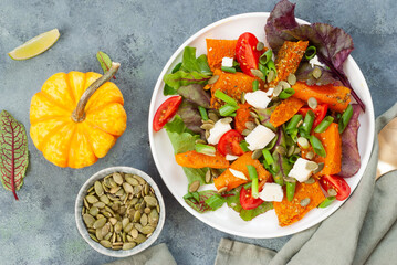 Pumpkin salad with cheese, tomatoes and pumpkin seeds