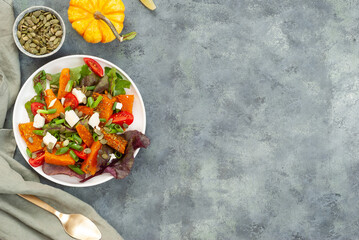 Obraz na płótnie Canvas Salad with pumpkin, cheese, mini tomatoes and pumpkin seeds. coppy spice